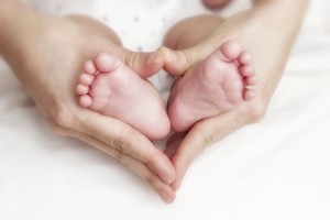 Baby Füße in den Händen einer Frau mit Kindwerwunsch